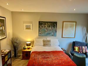 a bedroom with a bed and a chair at Modern, Gr Floor 1 bed, bathroom, garden & private entry. in Cambridge