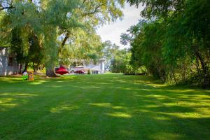 ein grünes Grasfeld mit Bäumen und einem Haus in der Unterkunft Nature Oasis BarMar 2BR Suite in Dundas close to Webster Falls in Dundas