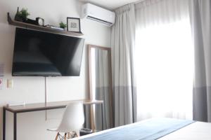 um quarto com uma cama, uma televisão e uma janela em CASA Azul Turquesa Excelente Ubicacion Facturamos em Guadalajara