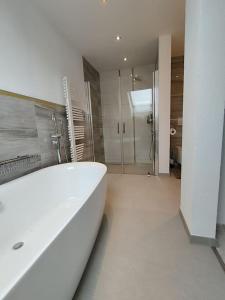 a white bathroom with a tub and a shower at Wolke7 in Frittlingen