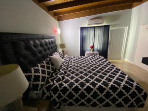 una camera da letto con un letto con un piumone bianco e nero di Portmore - Cheerful Private Bedroom with Fan only or AC - Choose your room a Portmore