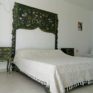a bedroom with a bed with a large headboard at Magnifique appartement djerbien in El Guecheïne