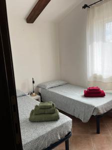 2 camas individuales en una habitación con ventana en La casetta di Minnannu, en Palau