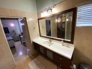 bagno con lavandino e specchio di Portmore - Cheerful Private Bedroom with Fan only or AC - Choose your room a Portmore