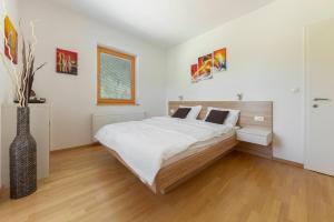 um quarto com uma cama grande e um vaso em Sunee Apartment em Kranjska Gora