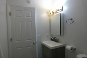 Baño blanco con lavabo y espejo en 410 E 45th Unit 1 en Anchorage