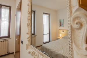 1 dormitorio con cama y espejo en Casa Olga - Bilocale con terrazzo zona fiera en Verona