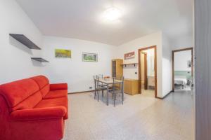 sala de estar con sofá rojo y mesa en Casa Olga - Bilocale con terrazzo zona fiera, en Verona