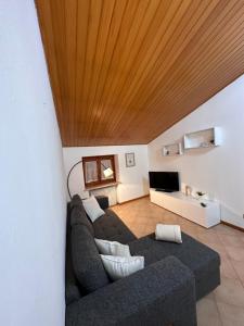 salon z kanapą i drewnianym sufitem w obiekcie Appartamentino via Aquileia w mieście Udine