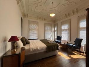 a bedroom with a bed and a desk and two chairs at Historic Greek Pavillion Golden Horn Istanbul in Istanbul