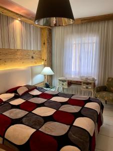 1 dormitorio con 1 cama grande y 1 mesa en Centro Gramado em frente a casa do Papai Noel, en Gramado