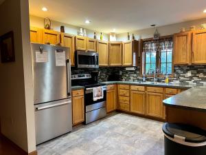 a kitchen with wooden cabinets and a stainless steel refrigerator at Mountain house in Palmerton