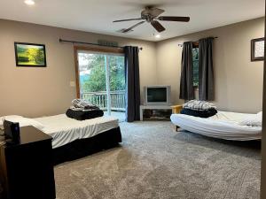 a bedroom with two beds and a tv and a fan at Mountain house in Palmerton