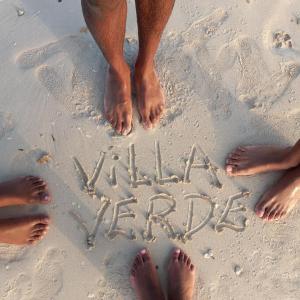 a group of people standing on the beach writing in the sand at Villa verde Jamaica - Oceanview Getaway, Gated & Secured in Falmouth