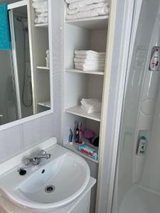 W łazience znajduje się umywalka, lustro i ręczniki. w obiekcie 6 berth caravan Cherry tree holiday park Great yarmouth w mieście Belton