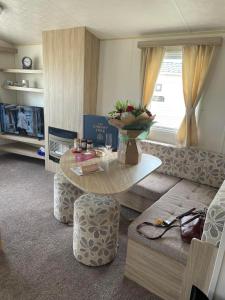 a living room with a table and a couch at 6 berth caravan Cherry tree holiday park Great yarmouth in Belton