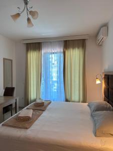 um quarto com uma cama grande e uma janela em Apartments Blanco em Budva