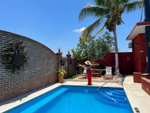 a swimming pool with a red fire hydrant next to a house at Casa Punta Perula VILLAS in Pérula
