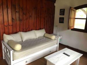 a white bed with pillows and a table in a room at Vacaciones en traslasierra Somos flexibles de precios, consulta y no te quedes sin vacacionar in San Javier