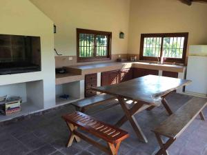 a kitchen with a wooden table and a bench at Vacaciones en traslasierra Somos flexibles de precios, consulta y no te quedes sin vacacionar in San Javier