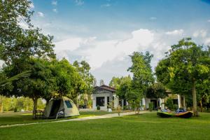 a tent in the grass in front of a house at Maravilla Kivu Eco Resort 