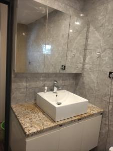 uma casa de banho com um lavatório branco e um espelho. em Breeze Apartments em Nadi