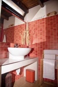 a bathroom with a sink and a red tiled wall at Aurora Mari Villa Your Dream Steps from the Ocean Shore in Caleta De Fuste