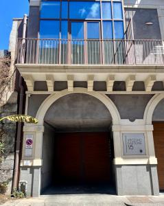 a building with a red garage with a balcony at Egregia Dimora in Catania