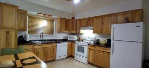 uma cozinha com armários de madeira e um frigorífico branco em 410 E 45th #3 em Anchorage