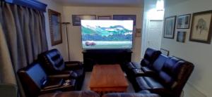 sala de estar con sillas y TV de pantalla plana en 410 E 45th #3 en Anchorage