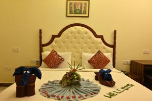 a bedroom with a bed with two stuffed animals on it at Andaman Galley Boutique Hotel in Port Blair