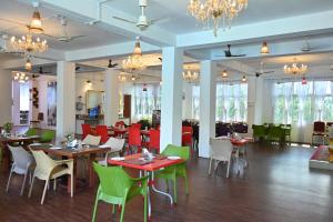 a dining room with tables and chairs and chandeliers at Andaman Galley Boutique Hotel in Port Blair