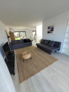 a living room with two couches and a table at Casa das Azorinas in Fenais da Luz