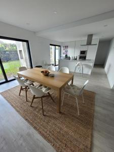 ein Esszimmer und eine Küche mit einem Holztisch und Stühlen in der Unterkunft Casa das Azorinas in Fenais da Luz
