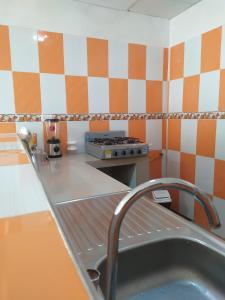 a kitchen with orange and white checkered wall at Casa Caribe in Santa Marta