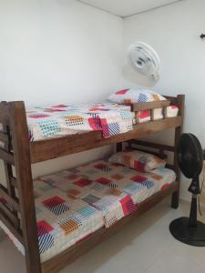 a bunk bed with a quilt and a fan at Casa Caribe in Santa Marta