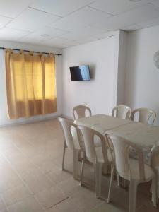a room with a table and chairs and a television at Casa Caribe in Santa Marta