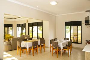 a dining room with two tables and a couch at Maravilla Kivu Eco Resort 