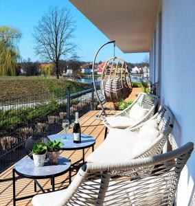a balcony with two chairs and a table with a bottle of wine at Randez-View Apartment in Iława