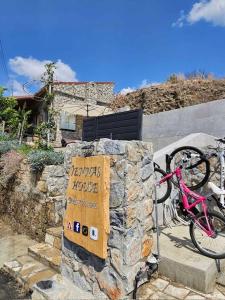 een roze fiets geparkeerd naast een rotsbord bij Jennas House in Arakapas