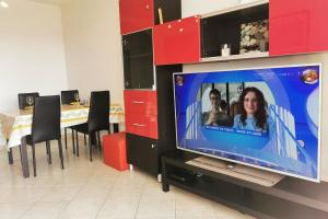 einen Flachbild-TV in einem Zimmer mit einem Tisch in der Unterkunft Charming 2-bedroom apartment Epsom B air-conditioned with parking in Cagnes-sur-Mer