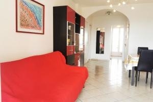 ein Wohnzimmer mit einem roten Sofa und einem Tisch in der Unterkunft Charming 2-bedroom apartment Epsom B air-conditioned with parking in Cagnes-sur-Mer