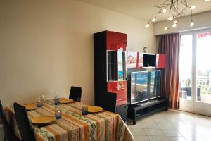 ein Esszimmer mit einem Tisch und einem TV in der Unterkunft Charming 2-bedroom apartment Epsom B air-conditioned with parking in Cagnes-sur-Mer