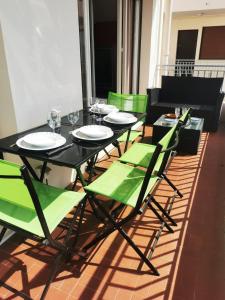 einen schwarzen Tisch mit grünen Stühlen und Weingläsern in der Unterkunft Charming 2-bedroom apartment Epsom B air-conditioned with parking in Cagnes-sur-Mer