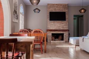 a living room with a table and chairs and a fireplace at Pousada João e Maria Gramado in Gramado