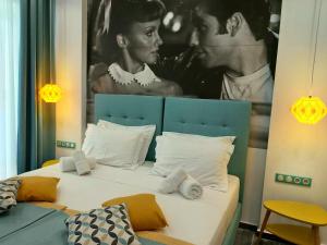 um quarto com uma cama com um quadro na parede em Nostalgia Retro Suites em Naxos Chora