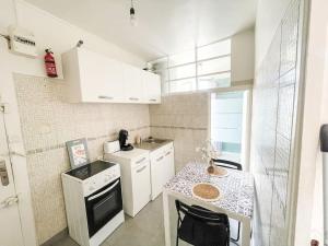 a kitchen with white cabinets and a counter top at Le Comfy Spot - Porte de Paris in Aubervilliers