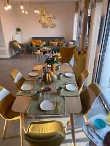 - une salle à manger avec une table, des chaises et un canapé dans l'établissement Villa des Cerisiers, à Saint-Nazaire