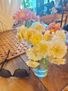 a vase of flowers next to a keyboard and glasses at Drilon Luxury Apartment in Tushemisht