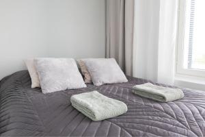 a bed with two pillows on top of it at City Apartment Matkatupa in Kuopio